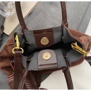 Detalle del bolso de gamuza marrón oscuro con cierre magnético y herrajes dorados
