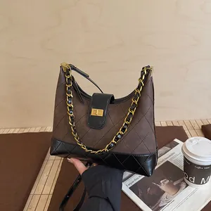 Λεπτομέρεια της ρετρό τσάντας hobo από καπιτονέ δέρμα και σουέτ με χρυσή αλυσίδα και κλείδωμα
