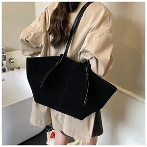 Détail du grand sac cabas noir mat avec bandoulières nouées porté par un mannequin