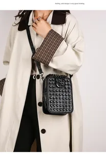 Detail shot of black studded crossbody bag worn with a coat for stylish street fashion