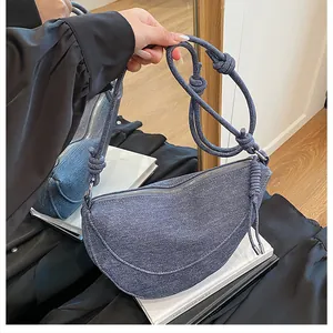 Λεπτομέρεια σκούρας μπλε τζιν τσάντας μισοφέγγαρο με σχοινί με κόμπους και μεταλλικό φερμουάρ