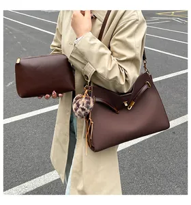Detalle de bolso tote vintage marrón mate con pompón de leopardo y bolso de mano a juego
