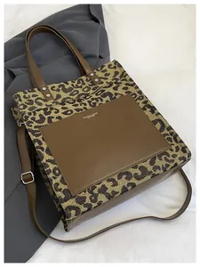 Λεπτομέρεια τσάντας tote με leopard print και καφέ δερμάτινη τσέπη με κείμενο