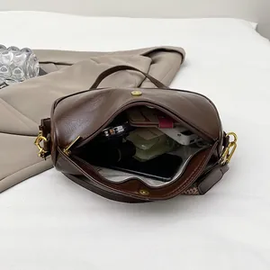 Retro dark brown pleated leather shoulder bag showing spacious interior and golden hardware