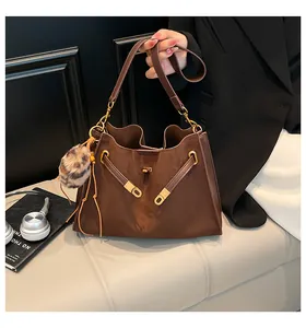 Detalle del bolso Kelly marrón oscuro mate con cierre de giro dorado y contraste