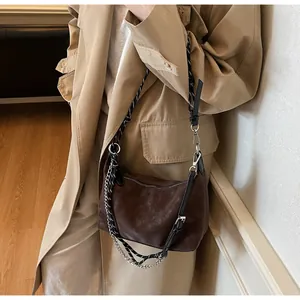Dettaglio borsa a tracolla in pelle scamosciata marrone con corda e catena d'argento