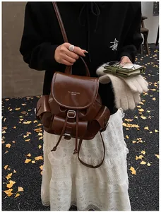 Detailed view of deep brown vintage leather backpack with flap pockets in autumn setting