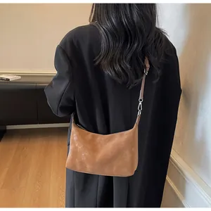 Dettaglio della borsa retrò marrone caramello in pelle opaca con tracolla sottile regolabile