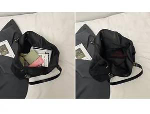 Detail showing spacious main compartment of a black tote bag with leather strap