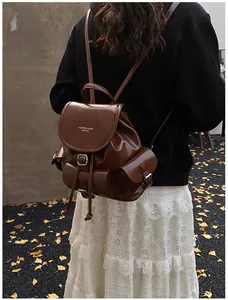 Detail of dark brown vintage leather backpack with polished finish and side buckle pockets
