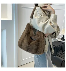 Détail du sac à main en fausse fourrure marron porté épaule avec une texture douce et chic