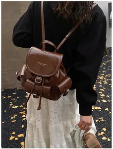 Close-up of vintage brown PU leather backpack featuring flap buckle and drawstring closure