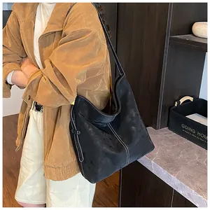 Große schwarze Wildleder-Hobo-Tasche mit weißen Kontrastnähten am Model gezeigt