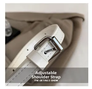 Detail of adjustable white patent leather shoulder strap with silver buckle and fine stitching