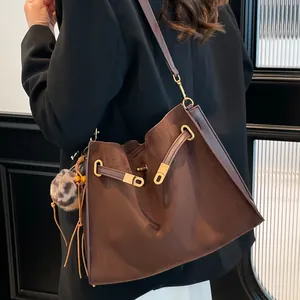 Bolso saco grande marrón vintage de cuero mate con flecos y colgante de leopardo al hombro