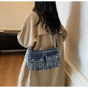 Retro denim shoulder bag featuring double front flap pockets and silver metal buttons