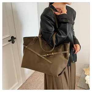Macro shot of retro dark brown suede tote bag featuring decorative belt and gold hardware