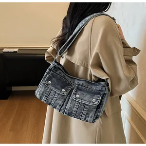 Close-up of retro washed denim shoulder bag featuring utility pockets with silver buttons