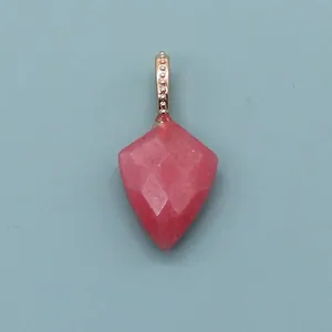 Macro view of geometric faceted pink natural stone pendant with gold bead bail detail