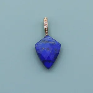 Detailed view of faceted lapis lazuli shield pendant with golden bead-edged clasp
