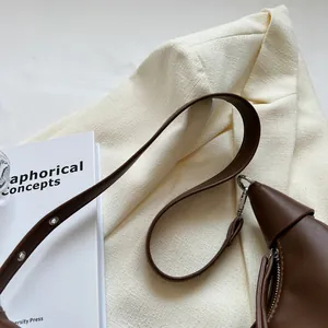 Λεπτομέρεια καφέ δερμάτινης τσάντας με ασημί φερμουάρ και γάντζους για ιμάντα ώμου