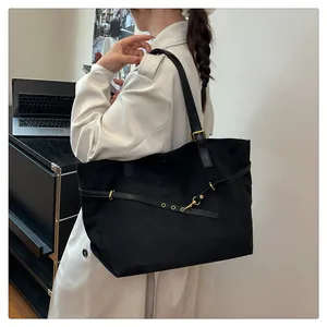 Side view of large black faux suede tote bag with golden hardware for daily commute