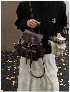 Detail view of dark brown vintage leather backpack with drawstring and flap closure