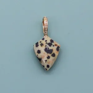 Detail of shield-shaped dalmatian jasper stone pendant with gold beaded texture bail