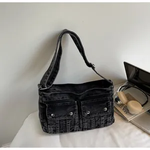Detail of vintage washed denim shoulder bag featuring double flap pockets and metal buckles