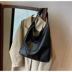 Λεπτομέρεια μαύρης vintage τσάντας tote με πτυχωτή υφή δέρματος κρεμασμένη σε κρεμάστρα ρούχων