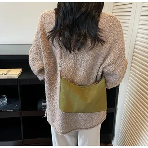 Dettaglio della borsa hobo in pelle scamosciata verde oliva con tracolla marrone