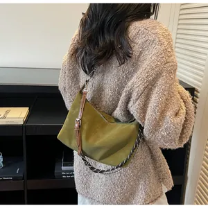 Dettaglio della borsa hobo verde avocado con tracolla in pelle e catena intrecciata