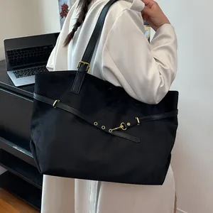 Large vintage black suede tote bag for women showing a stylish commute look on the shoulder