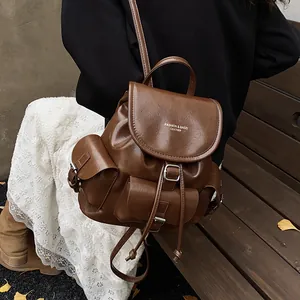 Vintage brown leather backpack for women with flap drawstring closure and multi-pocket design