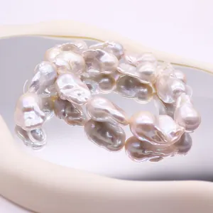 Perles de culture d'eau douce baroques aux reflets métalliques sur miroir à vagues