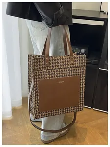 Λεπτομέρεια τσάντας tote με σχέδιο houndstooth, καφέ δερμάτινη τσέπη και λουράκι ώμου