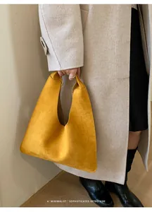 Detalle del bolso tote de ante amarillo minimalista con textura suave y estilo hobo chic