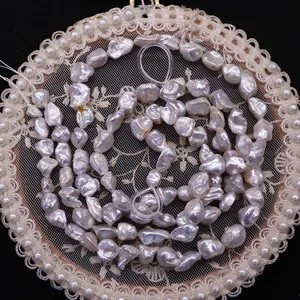 Natural baroque freshwater pearls strand with iridescent luster on vintage lace background