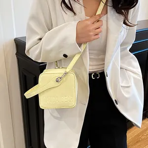 Minimalist pale yellow glossy square crossbody box bag with thin adjustable strap
