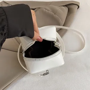 White patent leather mini square box bag with zip closure and slender shoulder strap