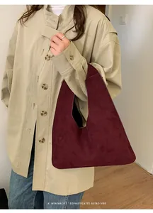 Elegante bolso tote de ante burdeos combinado con gabardina para un estilo de otoño