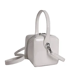 Glossy white box handbag with top handle and crossbody strap by Marhen J minimalist design