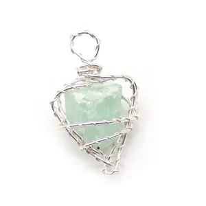 Detalle macro del colgante de corazón hecho a mano con piedra natural verde y alambre