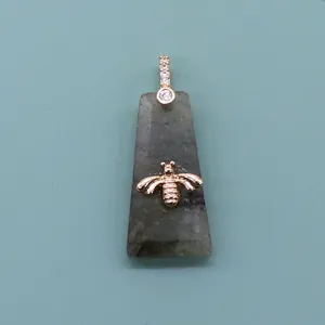 Detailed view of gray labradorite stone pendant featuring a golden bee ornament