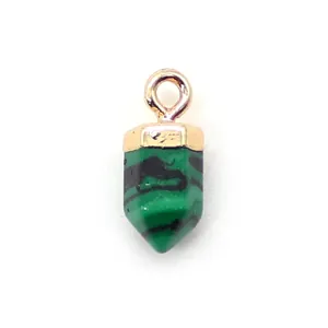 Detailopname van hexagonale malachiet kristallen hanger met gouden oogje voor DIY-sieraden