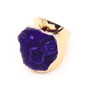 Detalle macro de piedra ágata púrpura natural en una banda de anillo dorado ancho