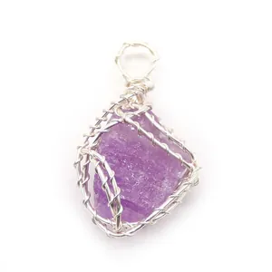 Dettaglio macro del filo d'argento avvolto a mano su un ciondolo in cristallo viola