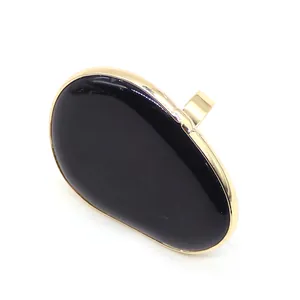 Close-up of teardrop black agate ring with polished gold metal adjustable band
