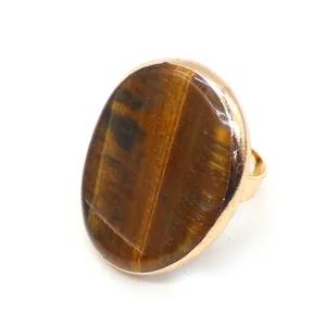 Macro shot of oval tiger eye stone set in adjustable gold-plated vintage metal ring