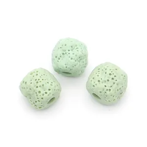 Macro detail of three light green porous volcanic stone cylinder beads for DIY jewelry